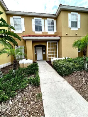a house with a sidewalk in front of it at Stylish 3 bd townhouse near Disney with private pool. in Kissimmee