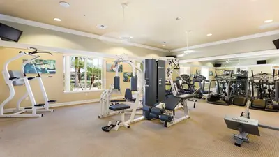 a gym with treadmills and machines in a room at Game Room 12BR Kids World Pool Spa Near Disney in Kissimmee