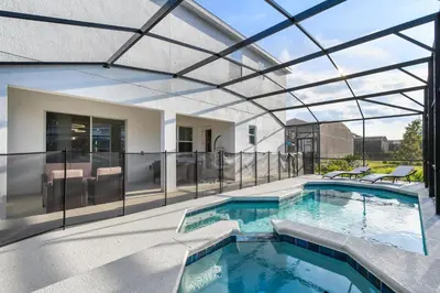 an indoor swimming pool with a glass roof at Game Room 12BR Kids World Pool Spa Near Disney in Kissimmee