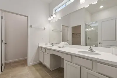 a white bathroom with two sinks and a mirror at Game Room 12BR Kids World Pool Spa Near Disney in Kissimmee