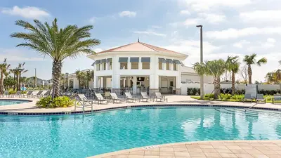 a pool in front of a house with palm trees at Themed Rooms & Pool in Storey Lake Resort in Kissimmee