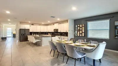a kitchen and dining room with a table and chairs at Cozy Home Storey Lake Resort Pool Spa Near Disney in Kissimmee