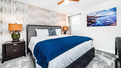 a bedroom with a bed with a blue comforter at Family Oasis: Pool, Themed Rooms & Resort Access in Kissimmee