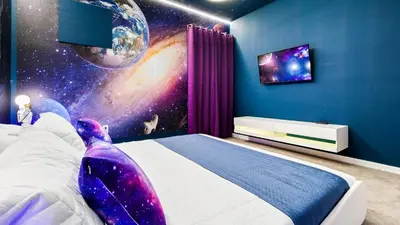 a bedroom with a space themed room with a bed at Luxury Home: Pool, Theater, Near Disney in Kissimmee