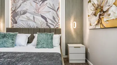 a bedroom with a bed and a painting on the wall at Luxury Home: Pool, Theater, Near Disney in Kissimmee
