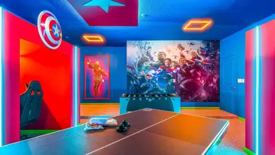 a room with a table and a superhero mural at Luxury Home: Pool, Theater, Near Disney in Kissimmee