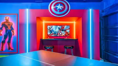 a room with a ping pong table and a captain america sign at Luxury Home: Pool, Theater, Near Disney in Kissimmee