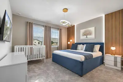 a bedroom with a blue bed and a window at Mario 12BR Villa w/ Private Green View Pool in Kissimmee