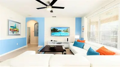 a living room with a white couch and a ceiling fan at Cozy 6br Home w/ Private Pool Spa in Windsor Hills in Orlando