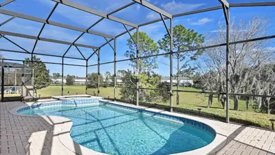 an indoor swimming pool with a clear glass roof at No Rear Neighbor 6BR Private Pool/Spa Near Disney in Orlando