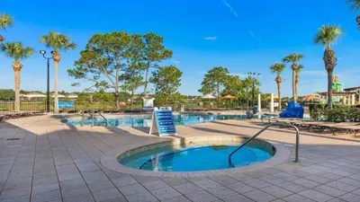 a small pool with palm trees in a park at Windsor Hills 6BR Villa Pool/SPA Close to Disney in Orlando