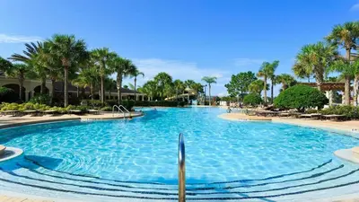 a large swimming pool with palm trees in a resort at Windsor Hills 6BR Villa Pool/SPA Close to Disney in Orlando