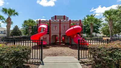 a playground with a red slide in front of a building at Windsor Hills 6BR Villa Pool/SPA Close to Disney in Orlando