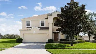 a house with a tree and a garage at Highland View 6BR Villa Private Pool Near Disney in Orlando
