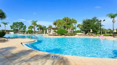 a large swimming pool at a resort with palm trees at Windsor Hill 6BR South-facing Pool/Spa Near Disney in Orlando