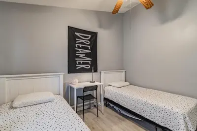 a bedroom with two beds and a table with a chair at Santee Villa in Kissimmee