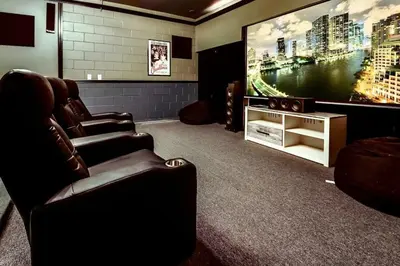 a living room with a couch and a large screen tv at Emerald Escape in Kissimmee