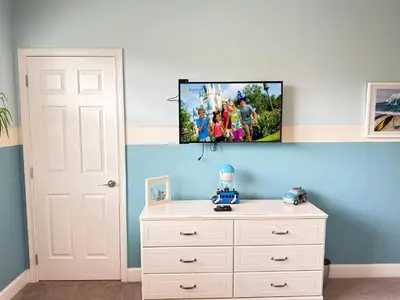 a bedroom with a dresser and a tv on the wall at 3 bedrooms pool home Retreat Close to Disney in Orlando