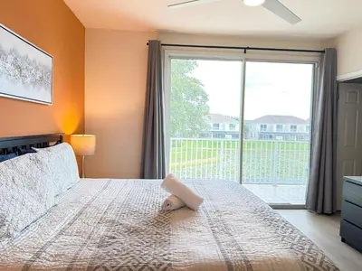 a bedroom with a large bed with a large window at Affordable Disney pool home 3 Bed 3 bath in Orlando