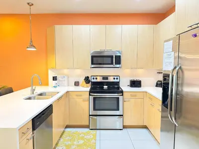a kitchen with a stove and a microwave at Affordable Disney pool home 3 Bed 3 bath in Orlando