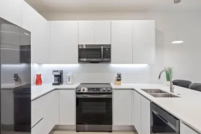 a kitchen with white cabinets and a black stove at 3 bedrooms pool home Hidden Forest Resort Amenities in Orlando