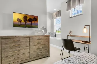 a bedroom with a dresser and a desk with a chair at 3 bedrooms pool home with clubhouse amenities Retreat in Orlando