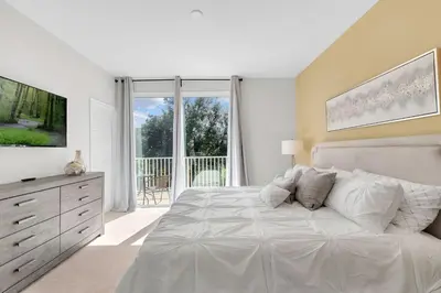 a white bedroom with a large bed and a window at 3 bedrooms pool home with clubhouse amenities Retreat in Orlando