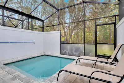 a swimming pool with chairs and a glass house at 3 bedrooms pool home Hidden Forest Resort Amenities in Orlando