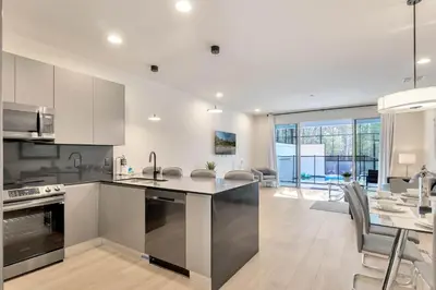 a kitchen with stainless steel appliances and a dining room at 3 bedrooms pool home Hidden Forest Resort Amenities in Orlando