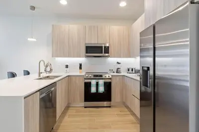 a kitchen with wooden cabinets and a stainless steel refrigerator at 3 bedrooms pool home Hidden Forest Resort Amenities in Orlando