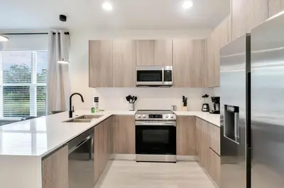 a kitchen with wooden cabinets and a stainless steel appliance at 4 bedrooms pool home Hidden Forest Resort Amenities in Orlando