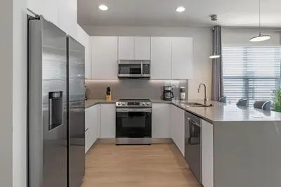 a kitchen with white cabinets and stainless steel appliances at 3 bedrooms pool home Hidden Forest Resort Amenities in Orlando