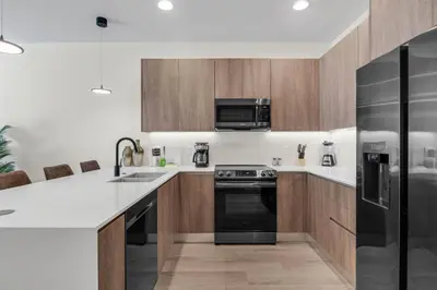 a kitchen with wooden cabinets and a black refrigerator at TR17126 - 3 Bed-3 bath w/pool near Disney sleeps 6 in Orlando
