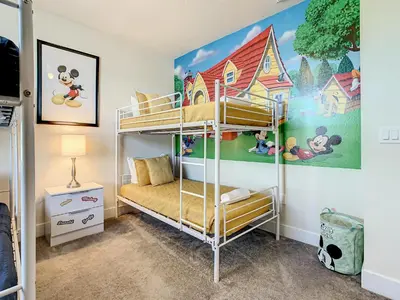 a bedroom with bunk beds with a mickey mouse mural at 3 bedrooms pool home Hidden Forest Resort Amenities in Orlando