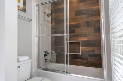 a bathroom with a shower with a glass door at Gorgeous 4 Suites DREAM Villa 5 min to Disney in Orlando