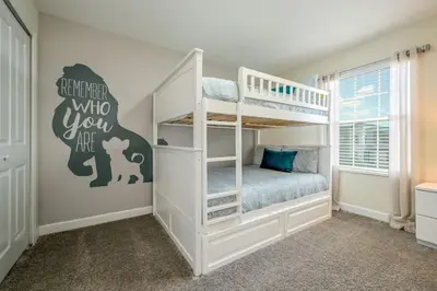a childs bedroom with a bunk bed with a white bunk bed at Magical Retreat, Spacious villa 10 min from Disney in Kissimmee
