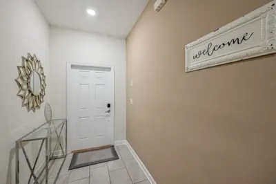 a hallway with a white door and a sign that reads welcome at Magical Retreat, Spacious villa 10 min from Disney in Kissimmee