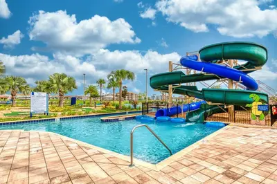 a water slide in a pool at a resort at Magical Retreat, Spacious villa 10 min from Disney in Kissimmee
