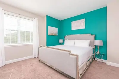 a bedroom with a bed and a blue wall at Luxury 6 BR 6 Bath @Encore Resort Pool Spa Grill. in Orlando
