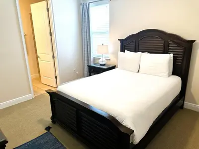 a bedroom with a large bed with white sheets and a window at 6 bedrooms pool home Encore Reunion Resort Gated in Orlando