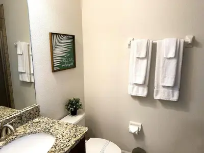 a bathroom with a sink and a toilet and towels at 6 bedrooms pool home Encore Reunion Resort Gated in Orlando