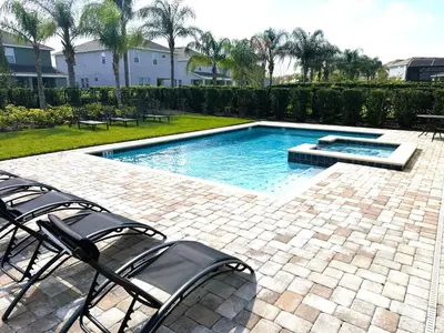 a swimming pool with chairs in a yard at 6 bedrooms pool home Encore Reunion Resort Gated in Orlando
