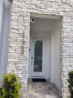 a brick building with a white door and a brick wall at 3 bedrooms pool home Hidden Forest Resort Amenities in Orlando