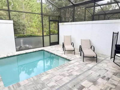 two chairs and a swimming pool in a building at 3 bedrooms pool home Hidden Forest Resort Amenities in Orlando