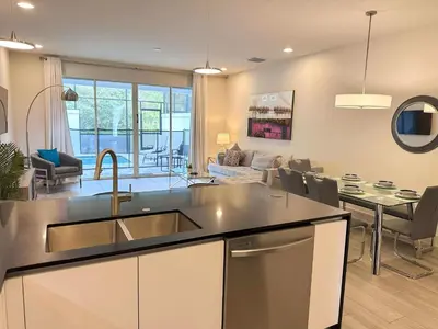 a kitchen and living room with a sink and a table at 3 bedrooms pool home Hidden Forest Resort Amenities in Orlando