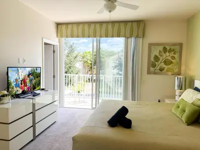 a bedroom with a large window and a television at Stylish 3-BR with Private Pool & Conservation View in Orlando