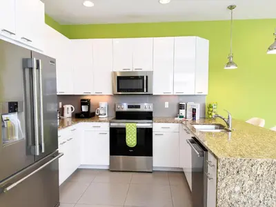 a kitchen with white cabinets and stainless steel appliances at Stylish 3-BR with Private Pool & Conservation View in Orlando