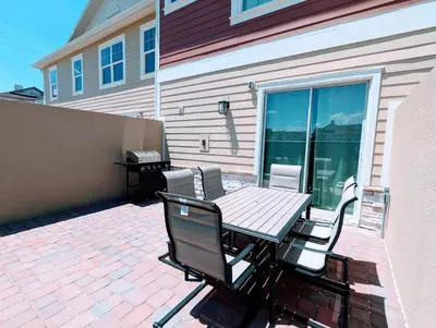 a patio with a table and chairs on a patio at Brand New 3 Suites 5 min to Disney in Orlando