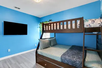 a bedroom with a bunk bed and a blue wall at Themed Luxury 6BR Getaway with Resort Amenities in Orlando