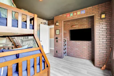 a room with a brick wall and a bunk bed at Themed Luxury 6BR Getaway with Resort Amenities in Orlando